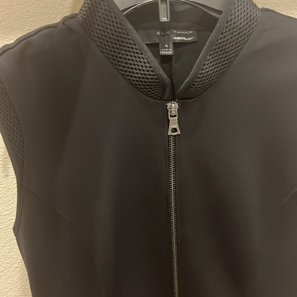 This is a black dress with a zipper and collar. It is an athletic material. - Picture 3 of 3